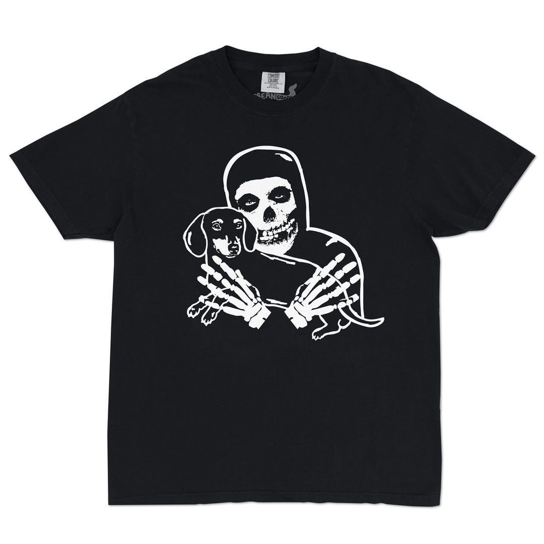 Black short sleeve t-shirt featuring a white graphic of a crimson skeleton figure holding a small dachshund, shown against a plain white background.