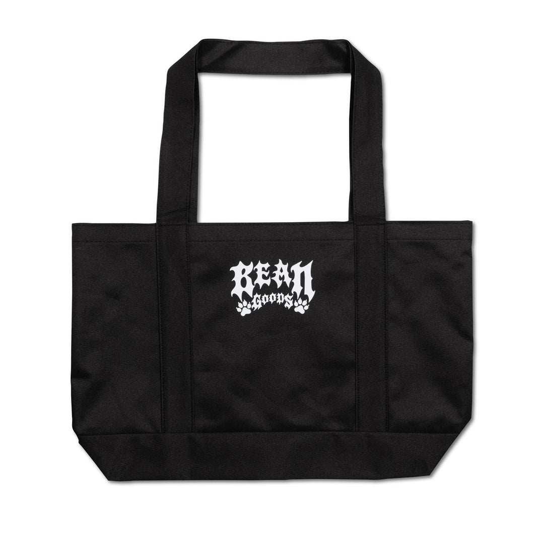 A black canvas tote bag with two shoulder straps and a white gothic-style 'BEAN goods' logo printed on the front, set against a plain white background.