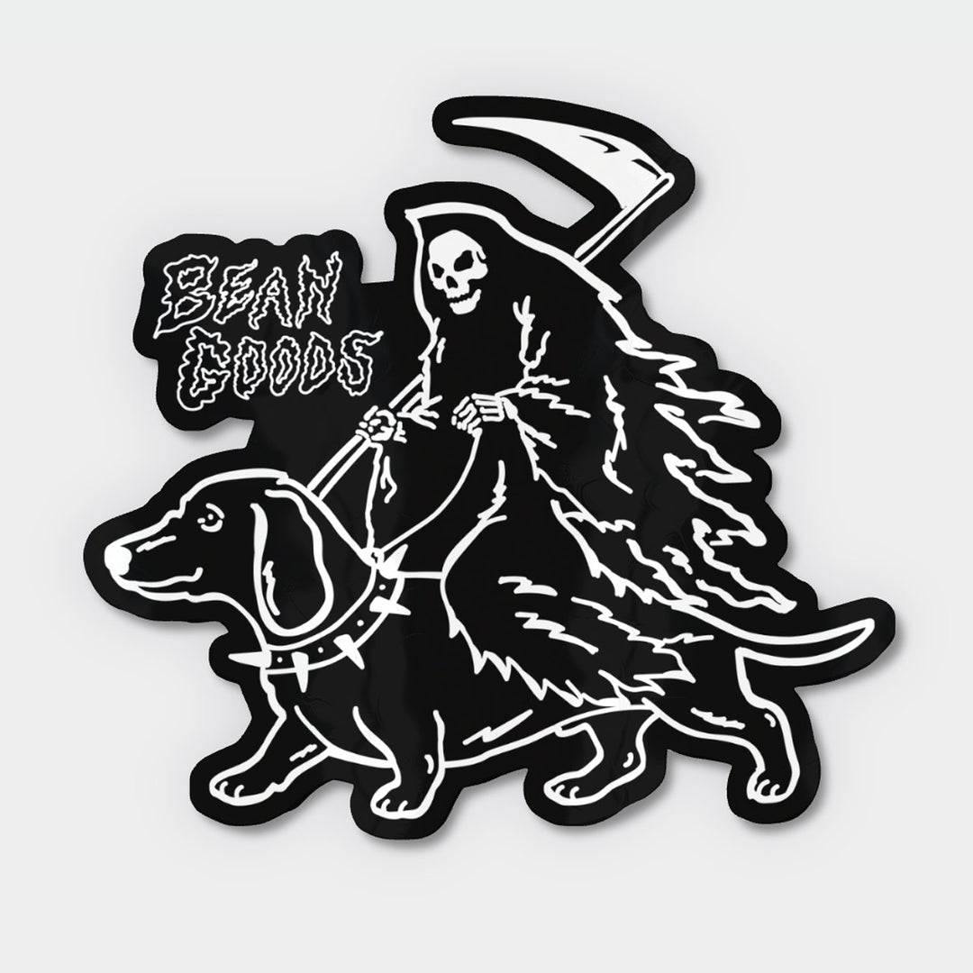 A black and white die-cut sticker featuring a grim reaper riding a dachshund, with the text 'BEAN GOODS' in a stylized font on the left, shown on a light gray background.